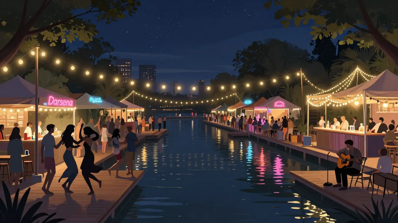 People dancing under string lights by a canal at night, with pop-up bars and reflections on the water.